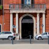 Al centro del piano inferiore (occupato da alcuni esercizi commerciali) si apre il portale d�ingresso con un arco a tutto sesto realizzato in pietra bianca...